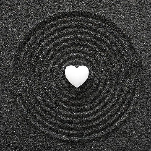 Japanese ZEN garden with white heart in black sand